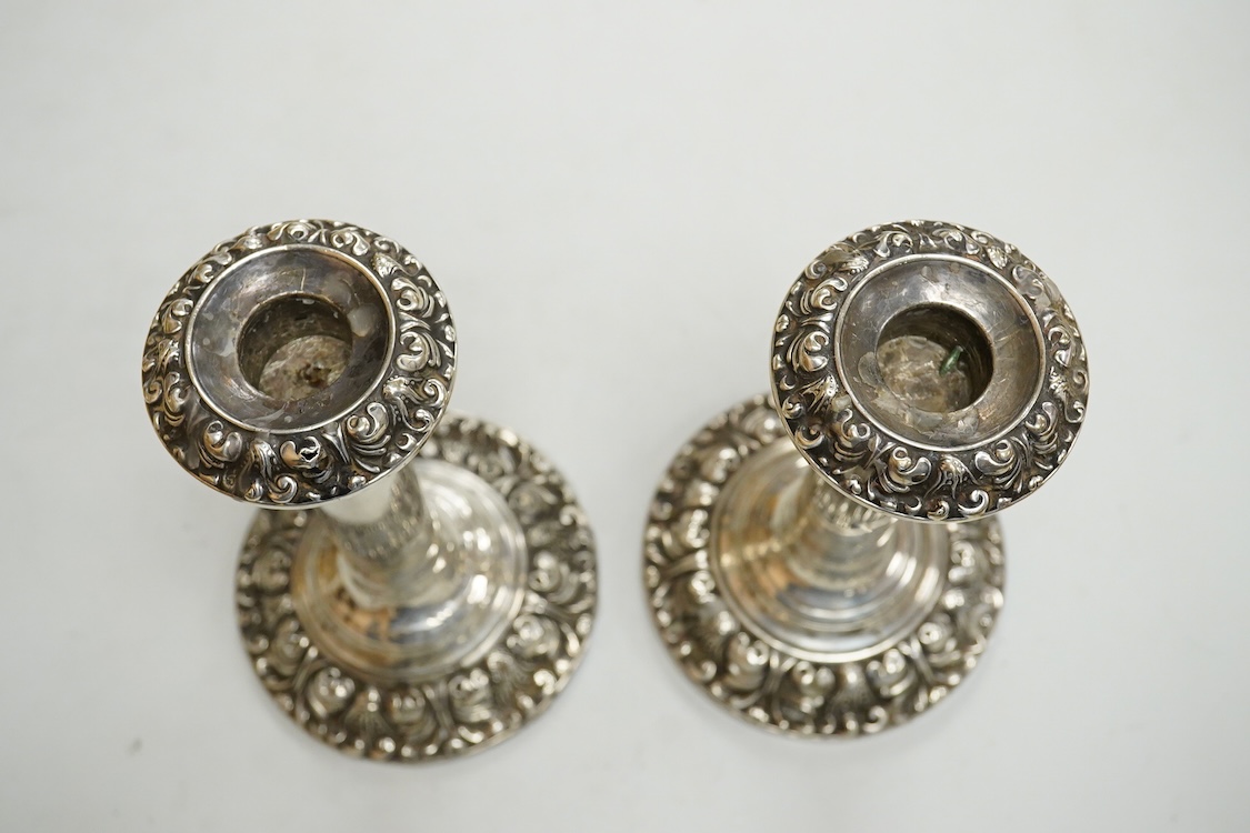 A pair of Edwardian silver mounted candlesticks, with embossed scroll bases, Martin, Hall & Co, Birmingham, 1906, height 19cm, weighted, (a.f.).